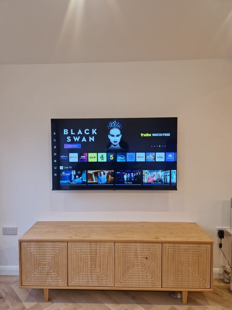 TV mounted above wooden cabinet