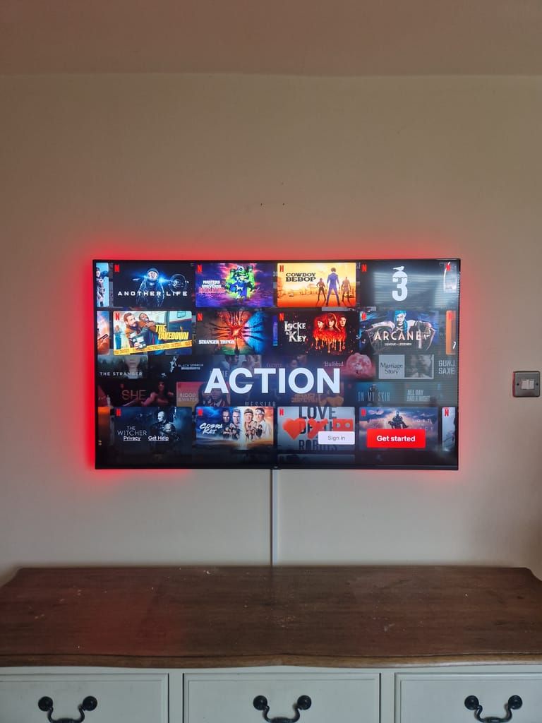 TV with red LED backlighting on white cabinet